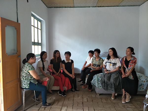 敦煌市女企业家协会会员与贫困母亲交谈了解生产生活及子女学习情况